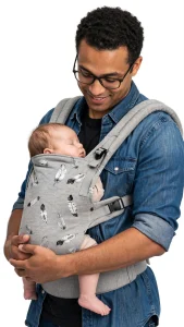 Papà con neonato addormentato in un marsupio ergonomico con spallacci imbottiti e fascia in vita