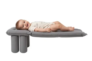 Bambino sdraiato su un materassino gonfiabile grigio che estende il sedile dell'aereo